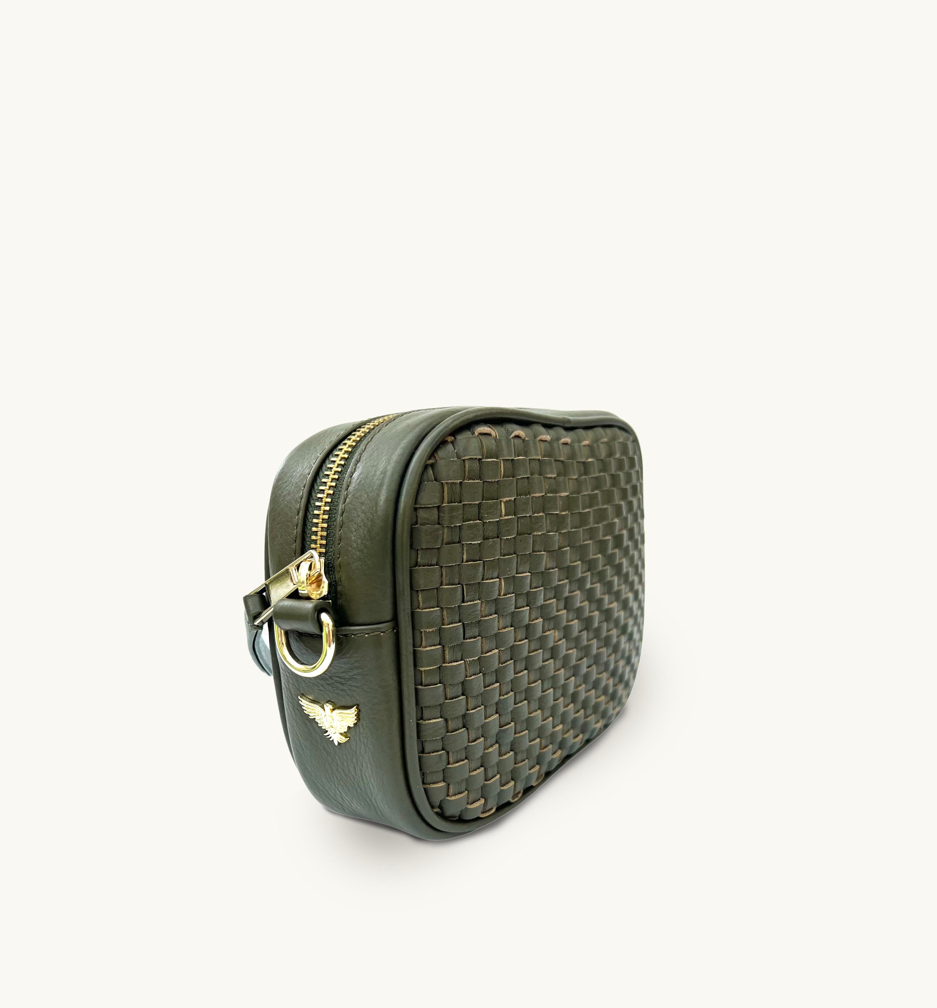Side view of a green woven handbag with the brand logo and gold zip