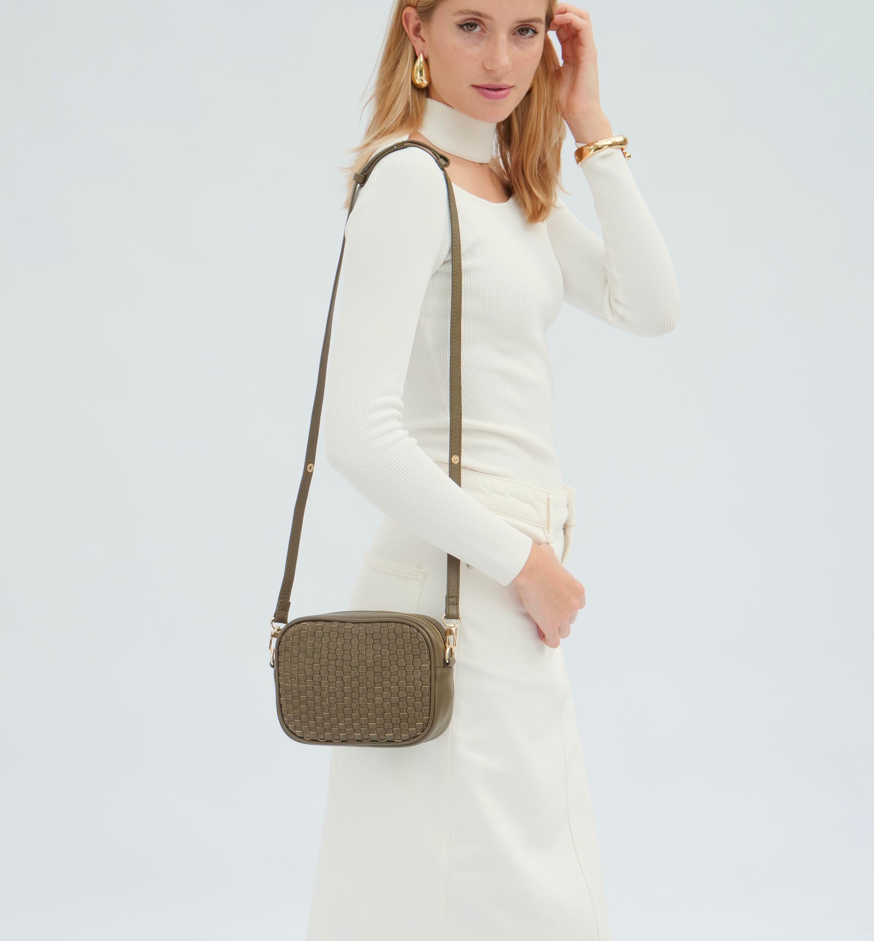 Green woven handbag worn as a crossbody bag on a white background