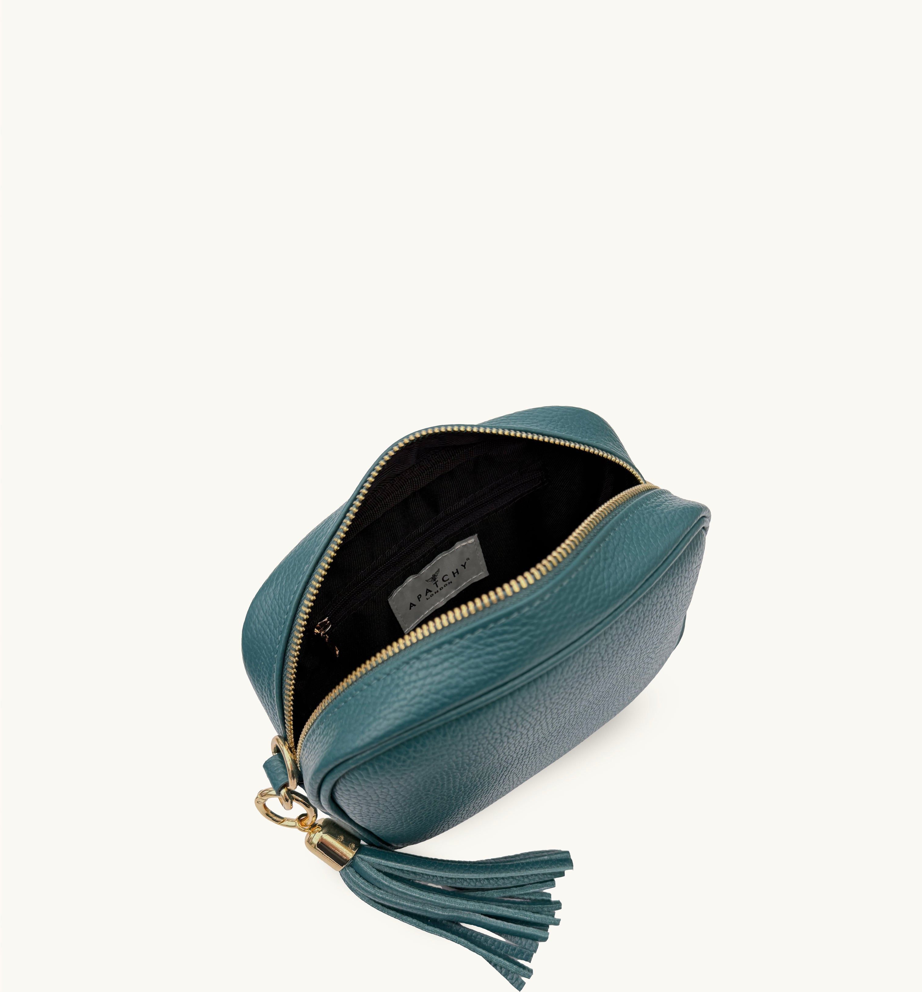 Teal leather bag with a tassel on a white background